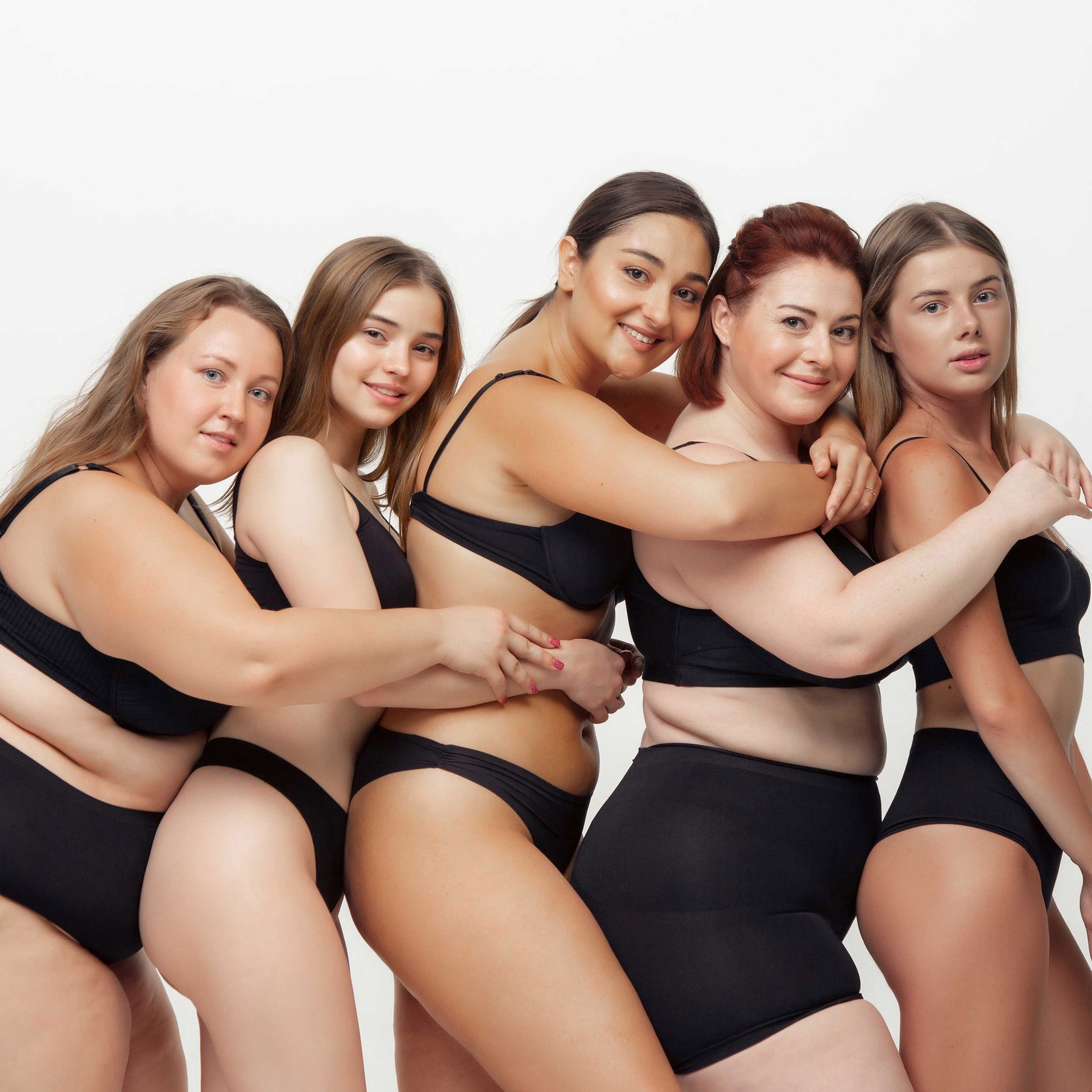 women with different body shapes hugging each other